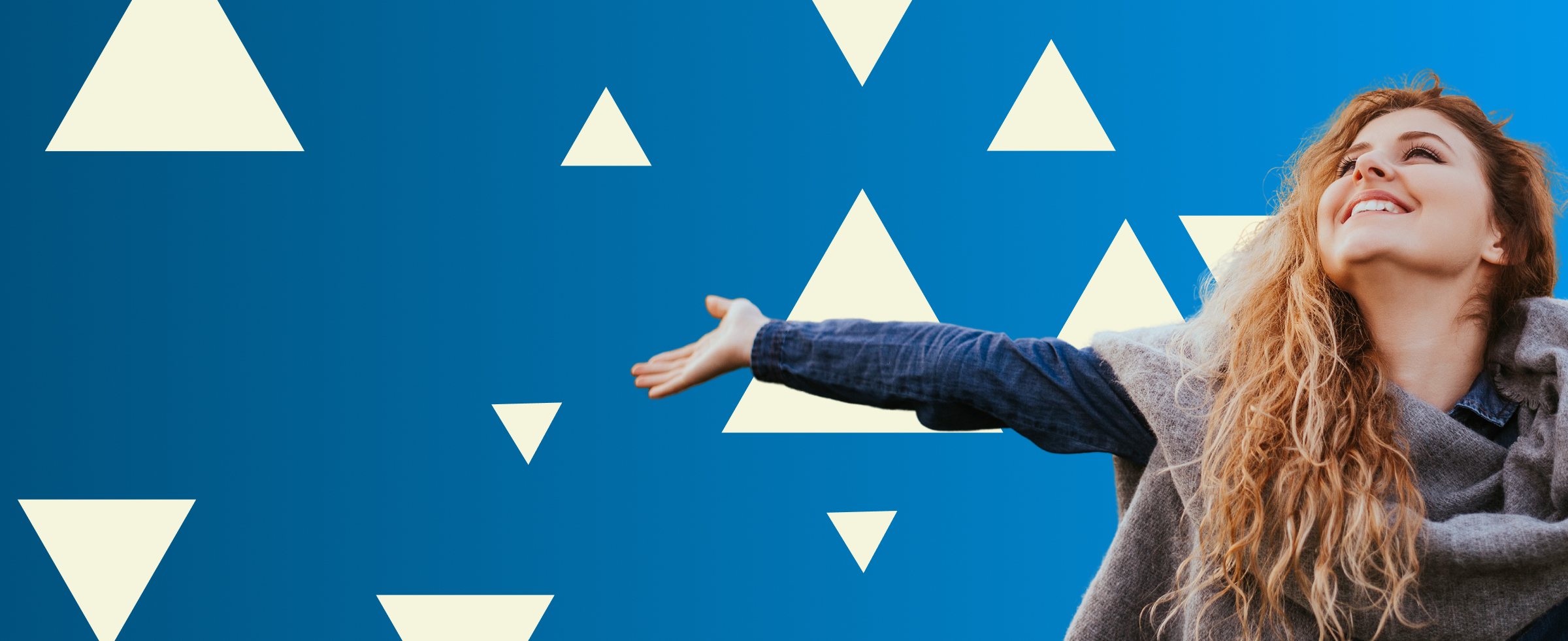 Nasmejana ženska z razprtimi rokami gleda navzgor proti svetlobi na modrem ozadju z belimi trikotniki kar izraža občutek svobode optimizma in navdiha