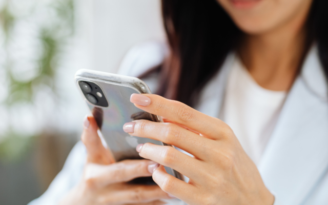 ženska drži telefon v roki, vidimo zelo od blizu