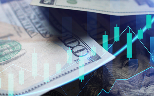 Na sliki so ameriški dolarji z digitalnimi borznimi grafikoni kar ponazarja finančne trge in investicije