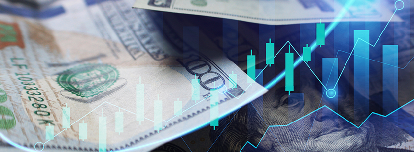 Na sliki so ameriški dolarji z digitalnimi borznimi grafikoni kar ponazarja finančne trge in investicije