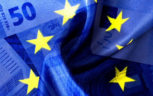 Na sliki je evropska zastava z zvezdami združena s podobo evrskih bankovcev kar simbolizira evropsko gospodarstvo in finančno unijo