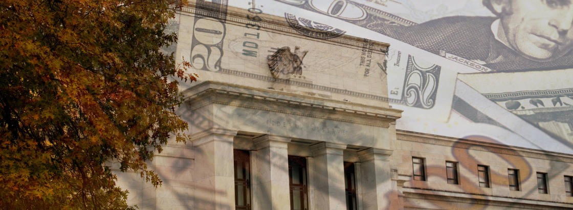 Slikovni preliv prikazuje stavbo centralne banke s pročeljem in ameriškimi dolarji kar simbolizira finančni sistem in monetarno politiko