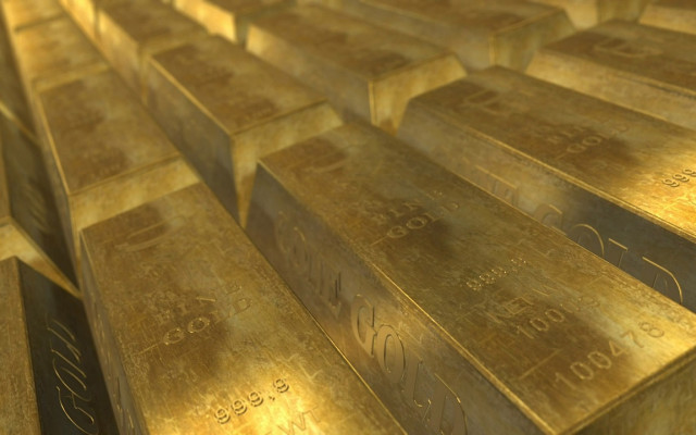Kup zlatih palic z napisom fine gold in oznako čistosti 999.9 leži v urejeni vrsti