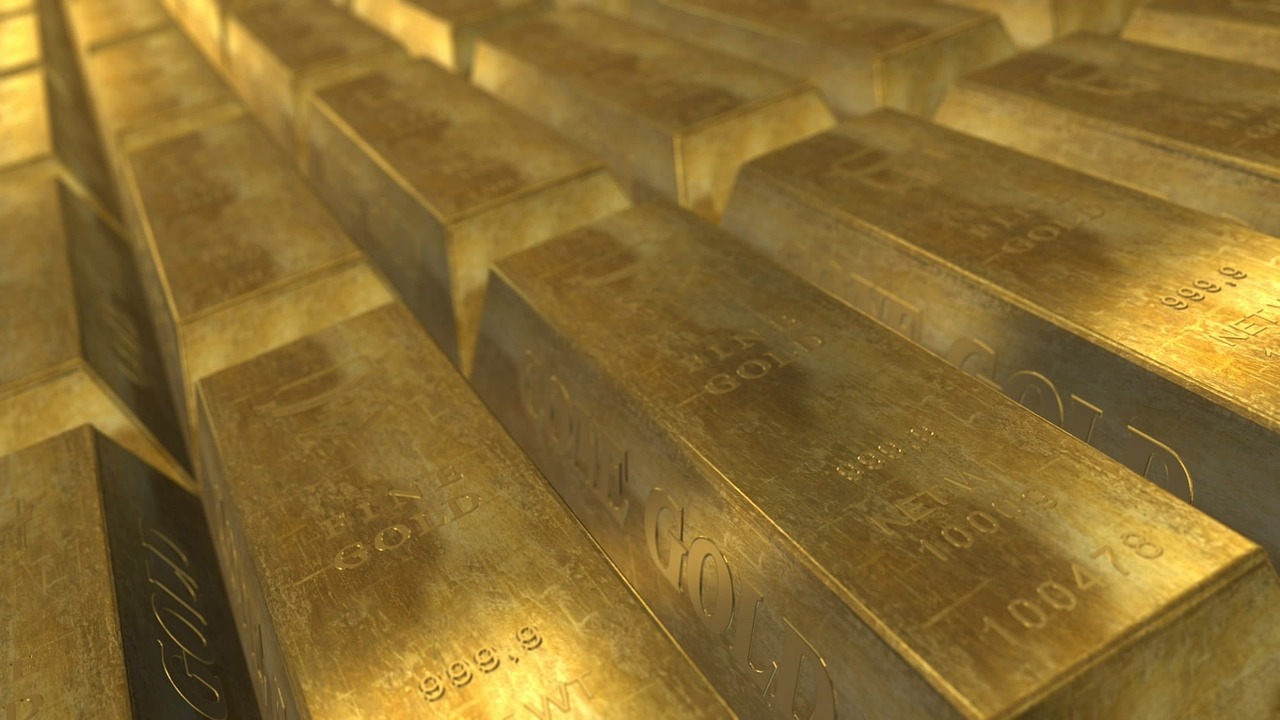 Kup zlatih palic z napisom fine gold in oznako čistosti 999.9 leži v urejeni vrsti