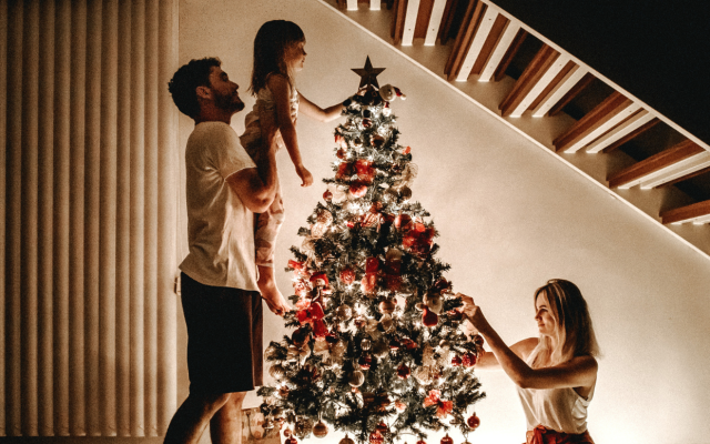 družina doma krasi božično jelko