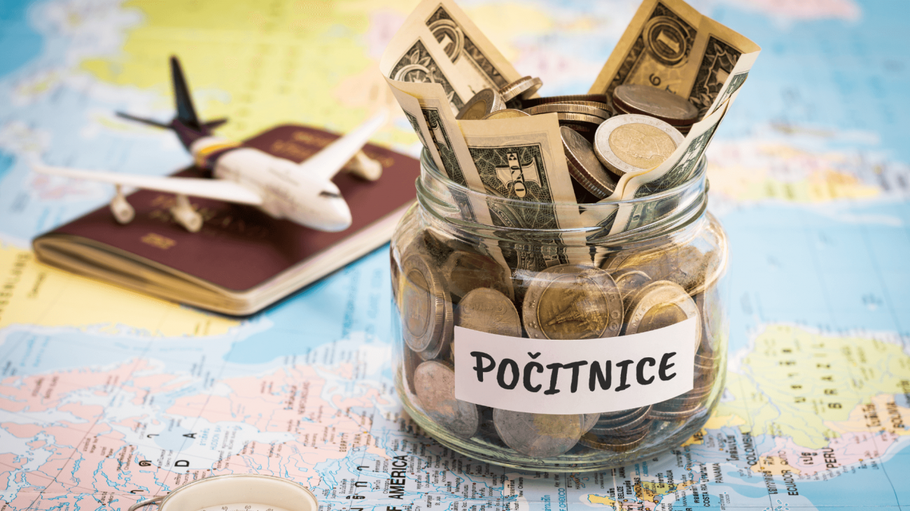 Slika steklenega kozarca, na katerem piše "počitnice", v njem je denar