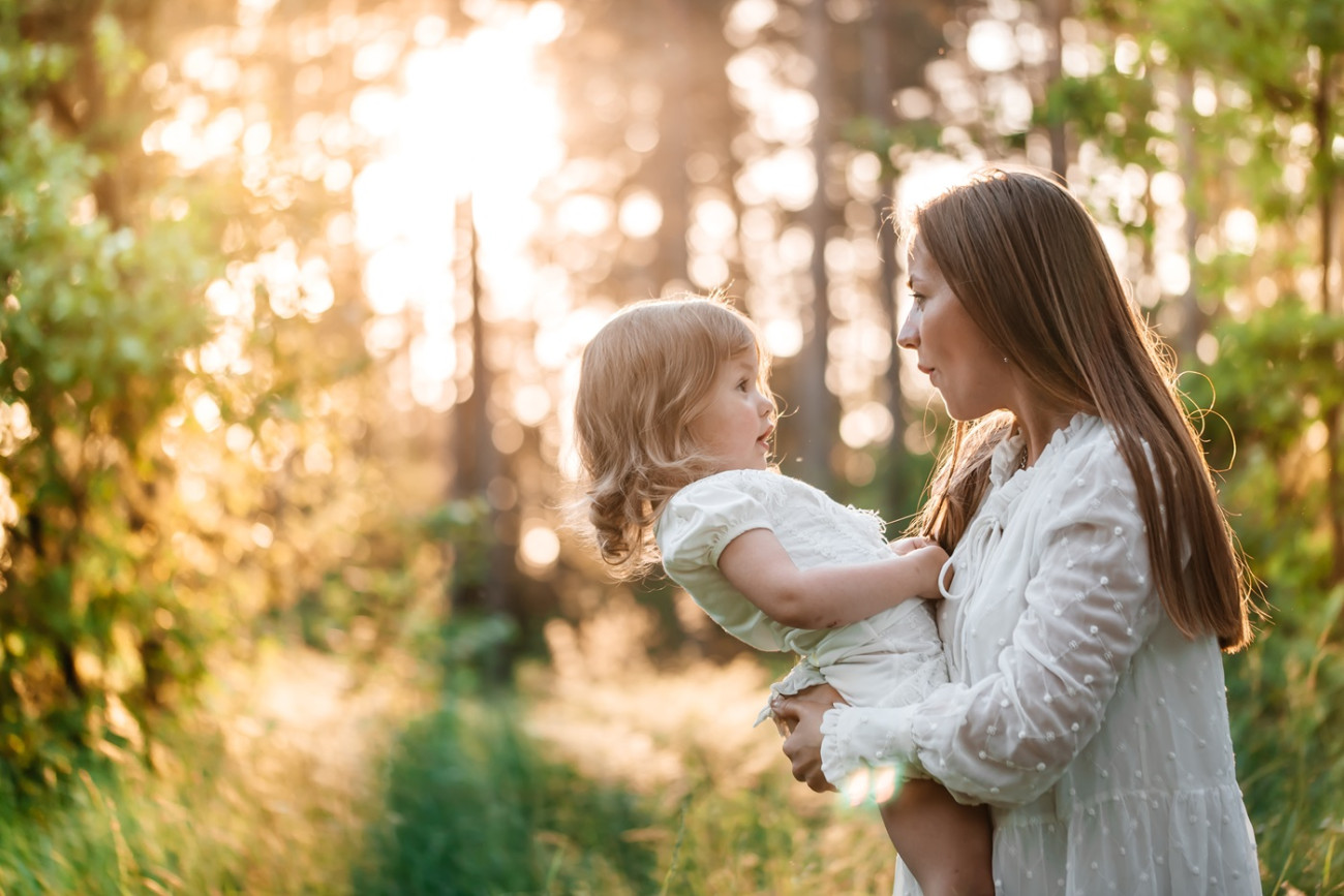 mama z malo puncko v parku ob soncnem zahodu