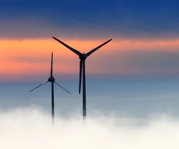 Slika dveh vetrnih elektrarn v sončnem zahodu