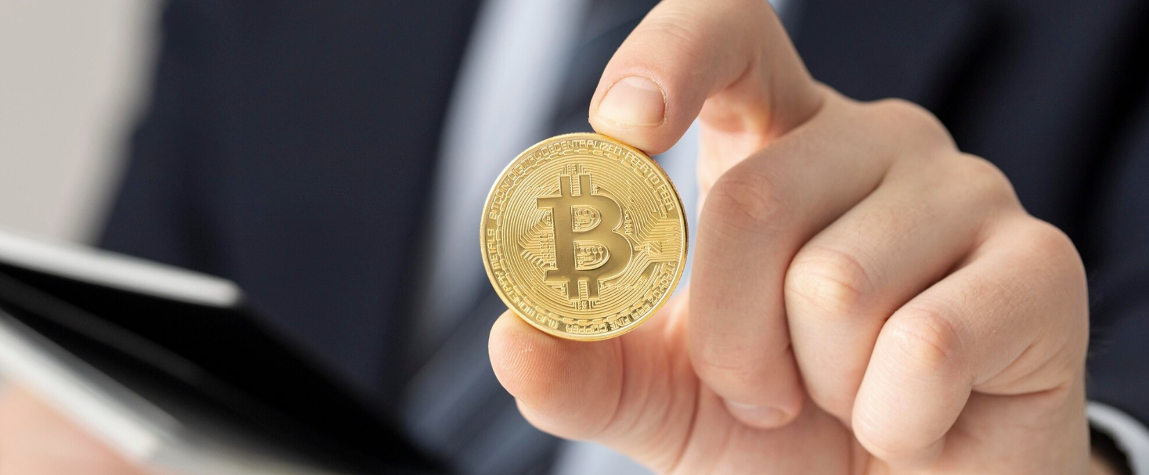 Slika osebe, ki v roki drži kripokovanec zlate barve.